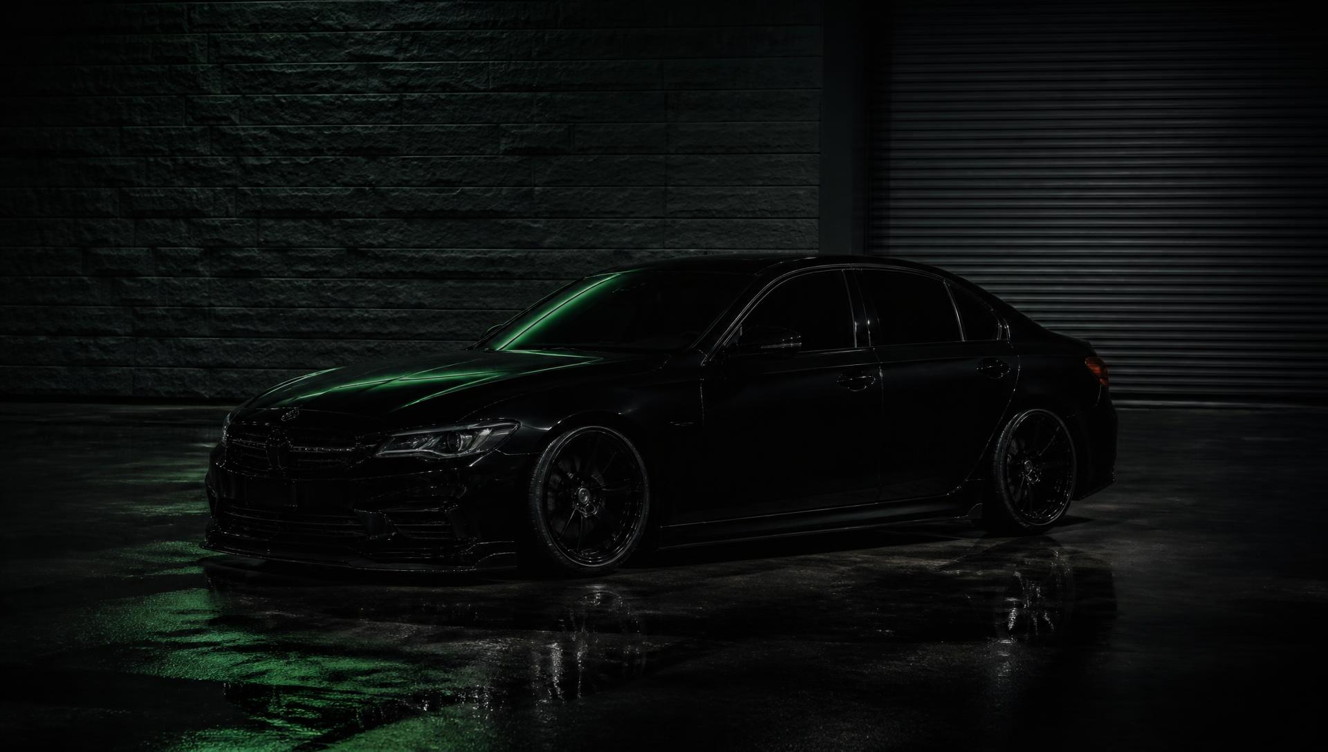 Blacked-out modified BMW at night outside the workshop